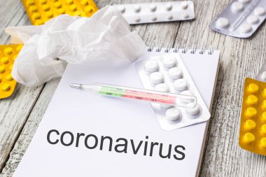 Coronavirus 'u tıbbi ilaçlar ve tabletlerle dolu bir arkaplanda not defterine yaz. Romantik Coronavirus 2019-nov