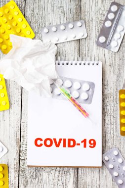 Coronavirus 'u tıbbi ilaçlar ve tabletlerle dolu bir arkaplanda not defterine yaz. Romantik Coronavirus 2019-nov