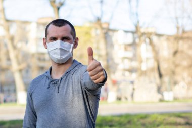 Korumalı maskeli adam sokak ortasında kameraya bakıyor. Enfeksiyonu durdur. Çin salgını koronavirüs konsepti