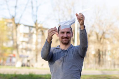 Beyaz bir adam sokakta yüz maskesi takıyor. - Ne? Enfeksiyonu durdur. Çin salgını koronavirüs konsepti