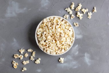 Gri masada beyaz kasede patlamış mısır. Kopyalama alanı olan üst görünüm