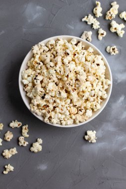 Gri masada beyaz kasede patlamış mısır. Kopyalama alanı olan üst görünüm