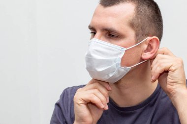 Koruyucu grip maskesini takan adamın portresi. Koronavirüse karşı koruma, grip, 2019-NCoV beyaz arka planda kapalı alan