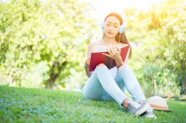 Öğrenci yaz tatilinde parkta kitap okuyor. Okula Dönüş İçin Hazır.