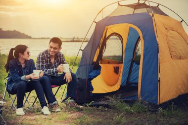 Aşk çifti doğa parkında gezer ve kamp yapar. Eğlence ve açık hava aktivitesi. Ormanda Turist Çadırı.