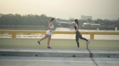 Plaj yolunda koşmadan önce sporcu kadın ısınıyor. Yazın Asyalı kadın dayanıklılık eğitimi. Sağlıklı yaşam tarzı ve spor anlayışı.