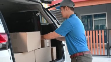 Taylandlı postacı paket ve posta kutularını kontrol ediyor. Asya çevrimiçi alışveriş servisi.
