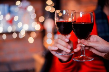 Çiftler gece partisi için kırmızı şarapla el ele tutuşur. Noel ve yeni yılınız kutlu olsun.