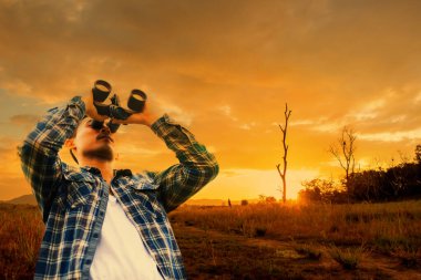 Ormanda kuş izleme ve yürüyüş parkurları. Yaz tatilinde açık hava aktivitesi ve dinlenme. Elinde dürbün tutan turist