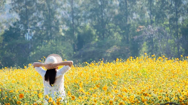 Asian women with blooming flower in the garden. Fresh spring and summer floral meadow.