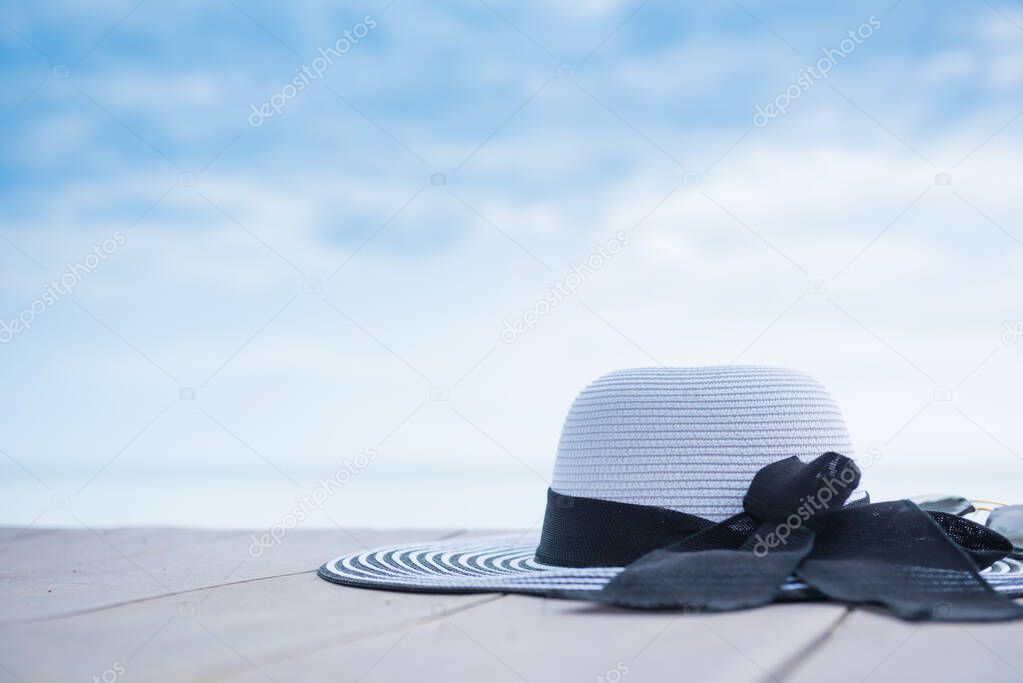 Women hat on the beach. Summer vacation with space on blue sky background.