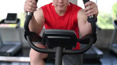 Spor salonunda bisiklete binme egzersizi. Sağlıklı ve zeki vücutlar için yaşam tarzı ve eğlence. Formda ve sıkı faaliyetler yavaşlar