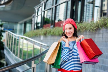 Yeni yıl ve doğum günü partisi için alışveriş hediyesi ve hediye. Alışveriş torbası tutan genç bir kadın.