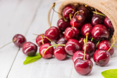 Çiftlikten taze kiraz, tatlı ve ekşi meyve, ahşap masa arka planı.