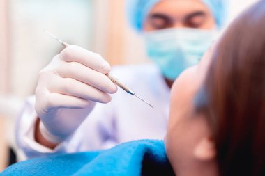 Diş hekimliğinde dişçilik ve sağlık konsepti. Genç Asyalı hasta için dişçi muayenesi.