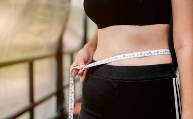 Bayan bel ölçü kablosu kullanıyor, fit ve sıkı vücut.