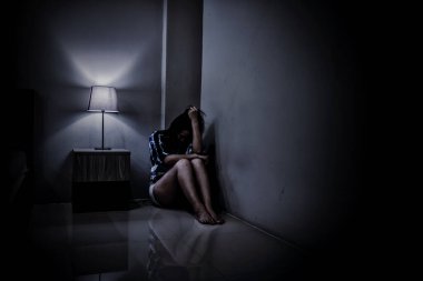 Depresyondaki kadın karanlık odada yalnız. Akıl sağlığı sorunu, travma sonrası stres bozukluğudur..