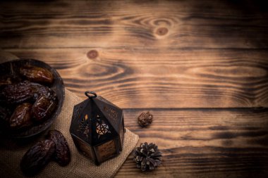 Mumlu Arapça fener ve ahşap masa üzerinde hurma meyvesi metin için kopyalama alanı ile.