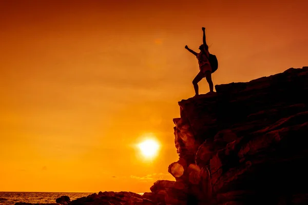 日没時に崖の上にスポーティな女性のシルエット 成功の概念 — ストック写真