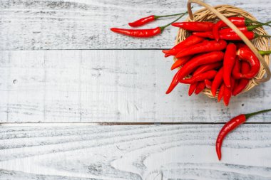 Ahşap masa arkasında acı ve baharatlı kırmızı biber.