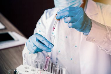 Bilim adamı ekibi Coronavirus tedavisini araştırıyor ve üzerinde çalışıyor. Asyalı Doktor, virüs enfeksiyonuna karşı numuneleri inceleyip aşı uyguluyor..