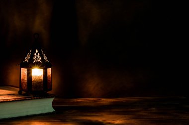 İslami bayram için gece mumlu Arap feneri. Müslüman kutsal Ramazan ayı. Bayram ve Mutlu Yıllar 'ın sonu. Boşluğu koyu arkaplanda kopyala.