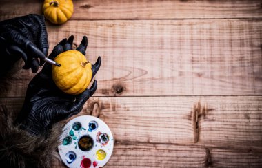 Mutlu Cadılar Bayramı. Kurt adam ya da zombi eller şaka mı şeker mi partisi için balkabağı boyuyor. metin için boşluk kopyala