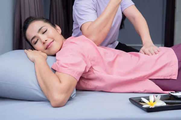 Kadın spada dinleniyor ve Tayland masajı yaptırıyor.