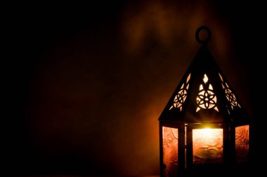 İslami bayram için gece mumlu Arap feneri. Müslüman kutsal Ramazan ayı. Bayram ve Mutlu Yıllar 'ın sonu. Boşluğu koyu arkaplanda kopyala.