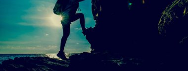 Sportif kadın uçuruma tırmanıyor. Başarı ve hedef kavramı. Açık hava aktiviteleri için güçlü ve sağlıklı..