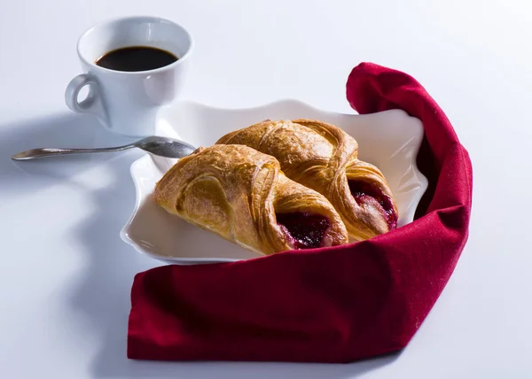 Croissants on a white plate with a napkin — Stock Photo, Image
