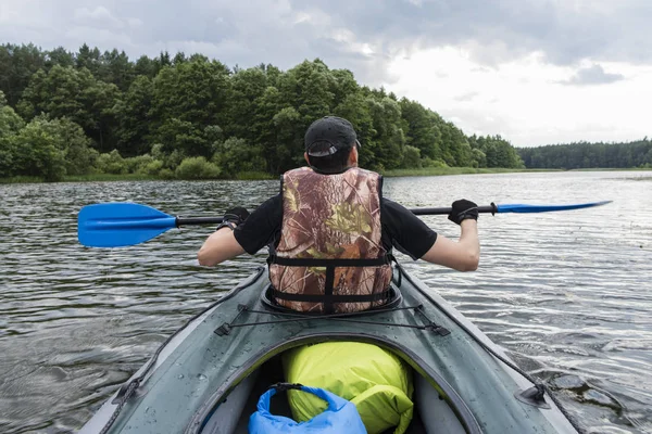 Un hombre remando un kayak —  Fotos de Stock
