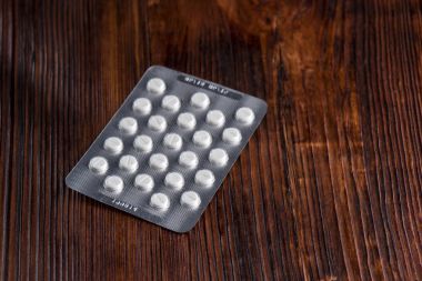 Ahşap arka plan üzerinde bir blister Tablet