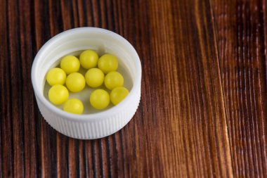 Ahşap arka plan üzerinde beyaz bir kapak c vitamini