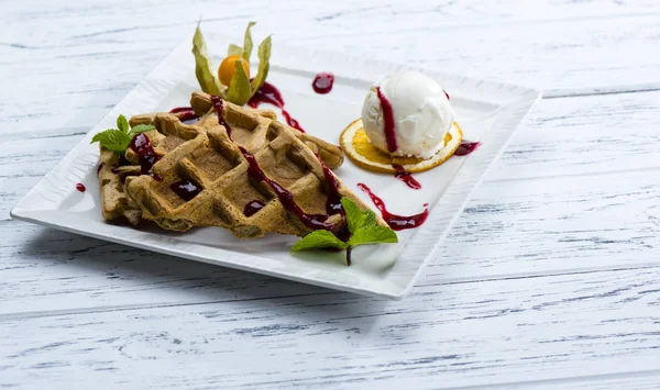 Viennese waffles with ice cream and syrup on a white plate and o — Stock Photo, Image