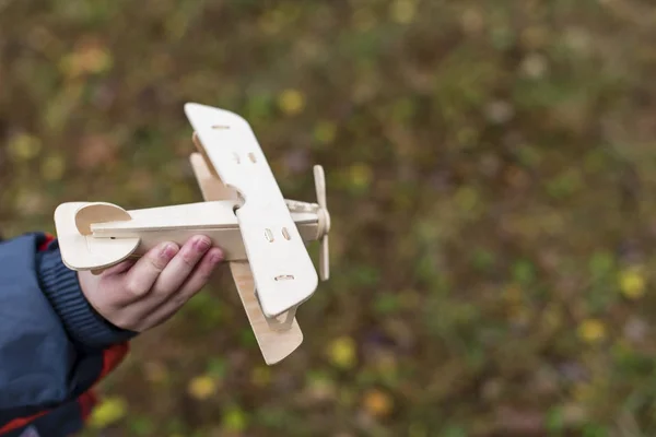 A wooden plane in the hands of a child — Stock Photo, Image