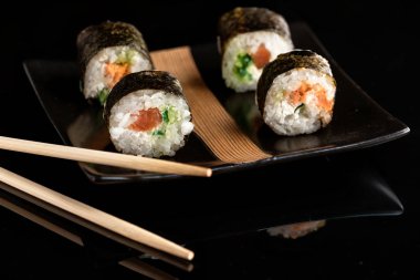 Zencefil ile siyah bir plaka üzerinde Japonca rulo