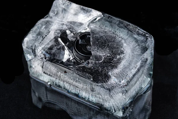 Камера заморожена в льоду на чорному тлі — стокове фото
