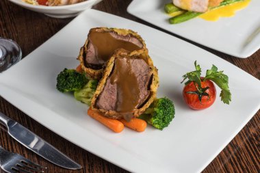 Fırında domuz eti, brokoli ve domates.