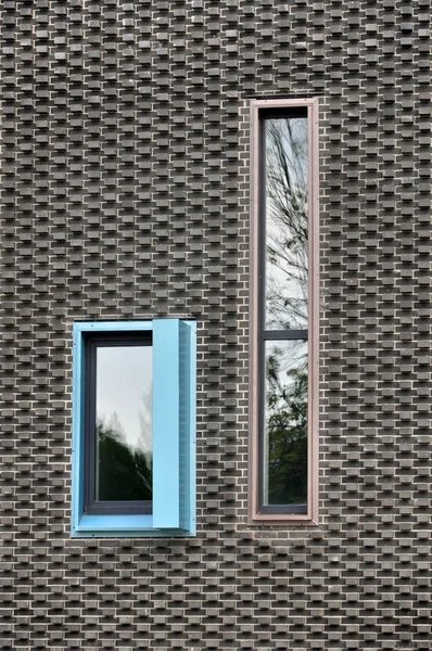 Twee vensters op zwarte bakstenen muur — Stockfoto