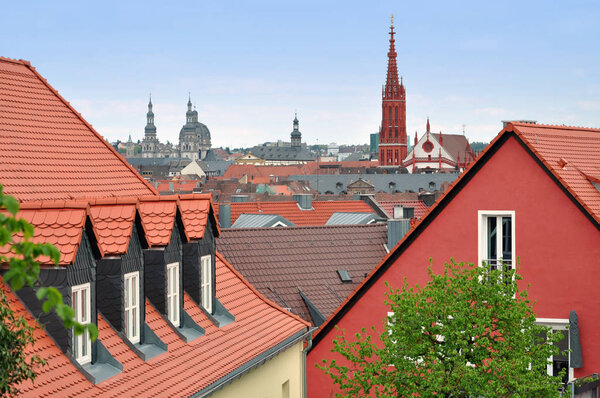Panorama of Wurzburg with ancient towers of churches. Pitched tiled roof in the foreground. Bavaria, Germany.