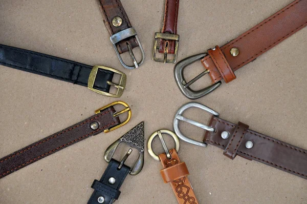 Many leather belts on cardboard — Stock Photo, Image