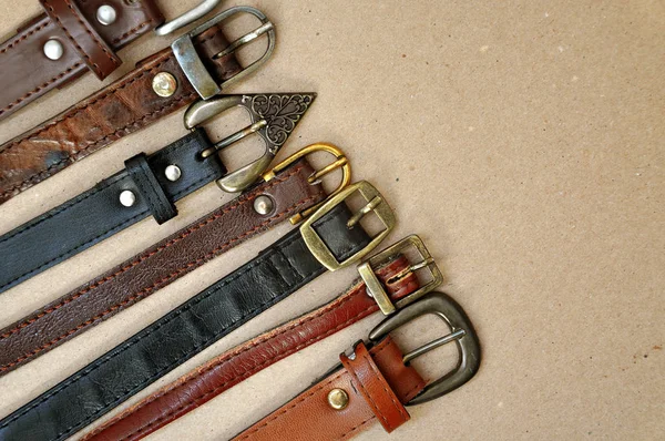 Many leather belts on cardboard — Stock Photo, Image