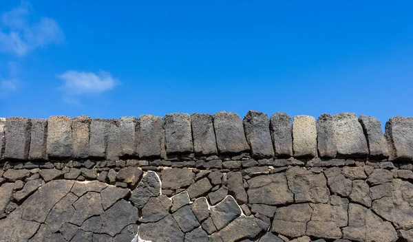 Stenen muur met blauwe hemelachtergrond — Stockfoto