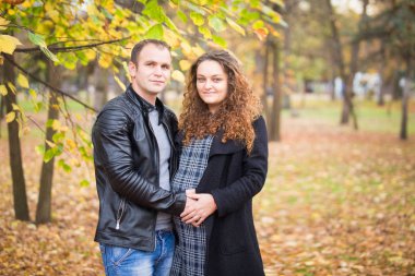 Mutlu hamile çift sonbahar arka planında