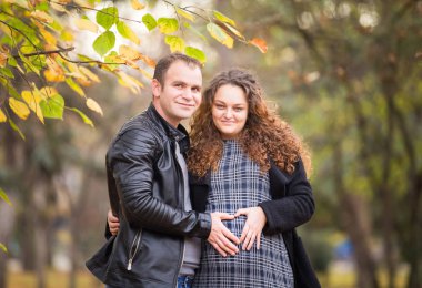 Mutlu hamile çift sonbahar arka planında