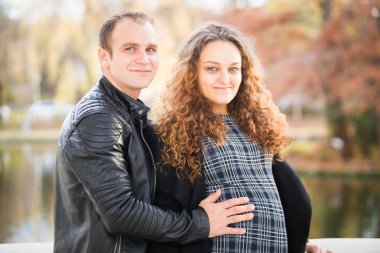 Mutlu hamile çift sonbahar arka planında