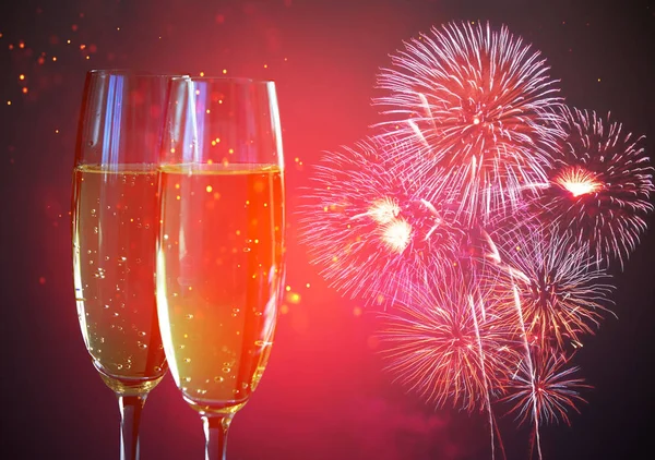 Yeni yıl şampanya kadehleri ve havai fişekler.