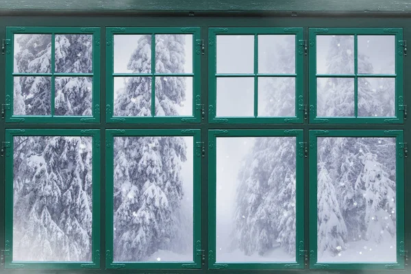 Dışarıda karlı köknar ağaçları olan pencere çerçevesi 