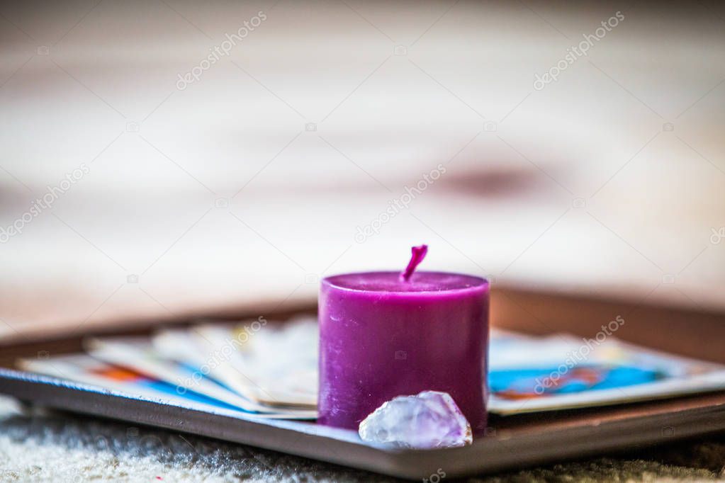 Tarot cards and purple candle esoteric background
